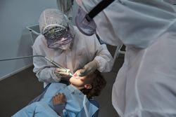 Dentist treating teeth of boy in dental office