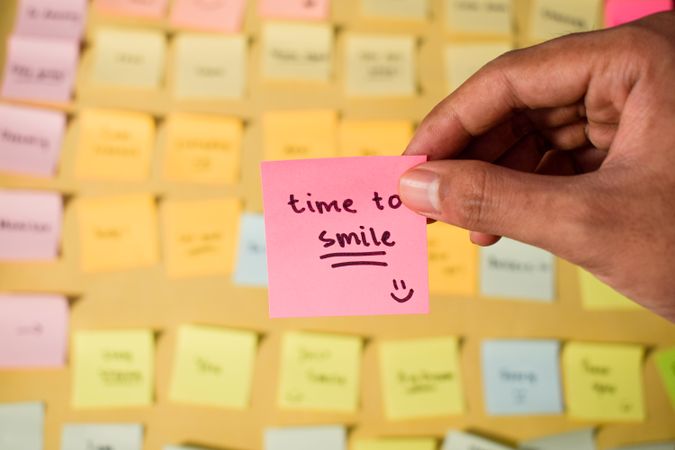 Hand hold sticky notes with words Time to Smile