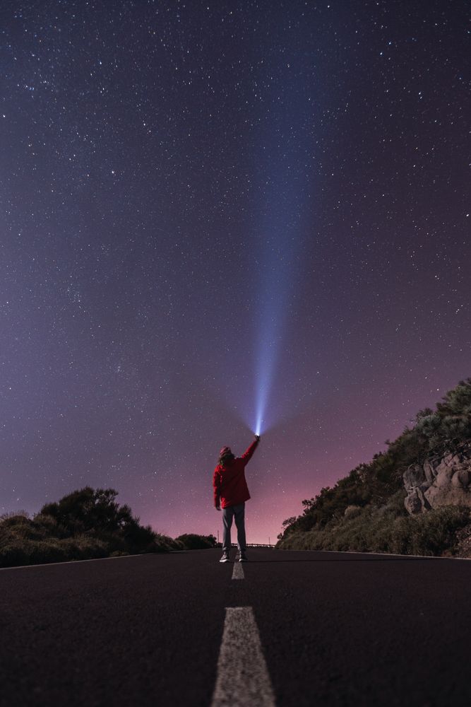Traveler standing with torch at starry night