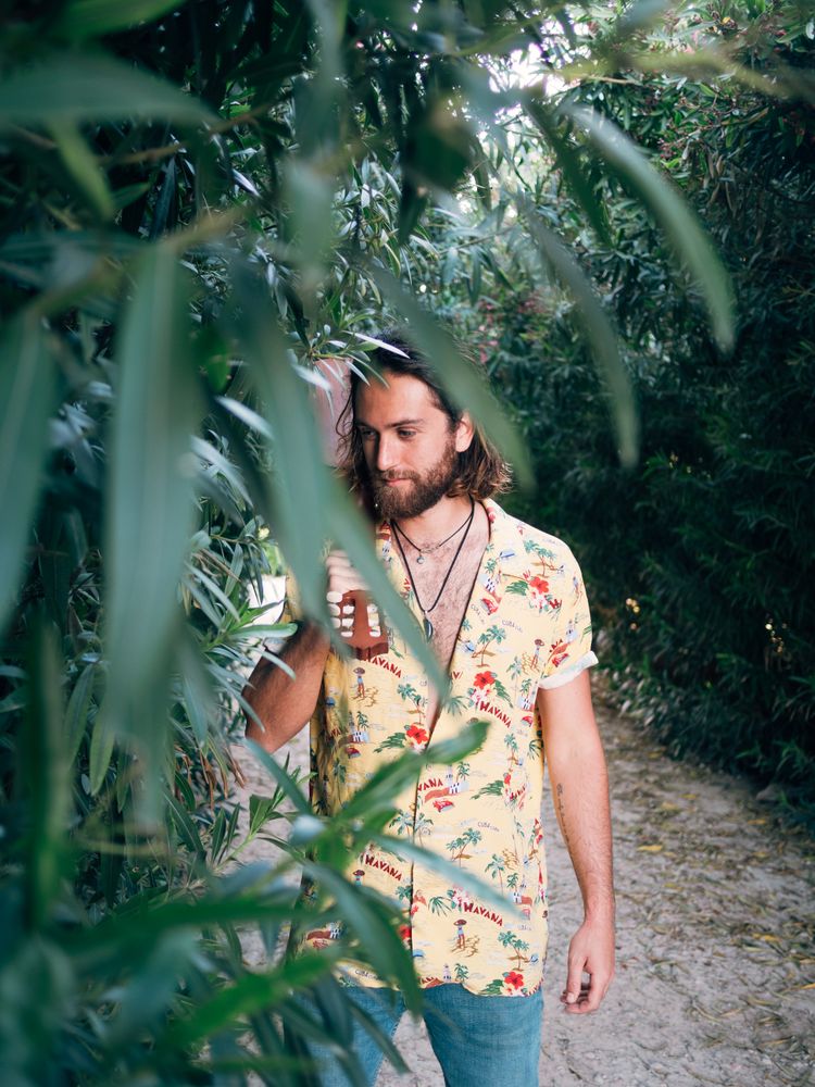 Hipster man in jungle with ukulele