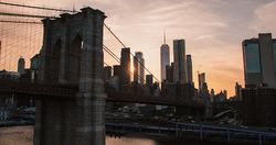 Aerial Cinematic Drone Scene Near the Brooklyn Bridge with Lower Manhattan Skyscrapers Cityscape. Beautiful Evening Sun Shining with Warm Sunset Light. Shot of a Suspension Bridge Architecture