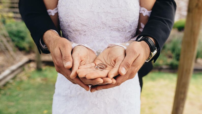 Close up of two wedding rings on newly married couple's hands