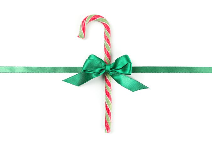 Sweet candy cane with bow isolated on plain background