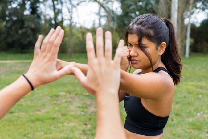 Female boxer training boxing sparring and punching outdoors