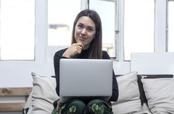 Woman sitting at home and using laptop