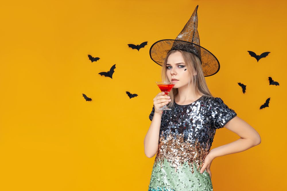 Concept of Halloween, young woman on yellow background