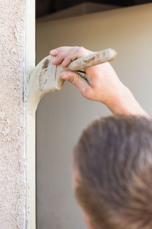 Professional Painter Cutting In With Brush to Paint House Door Frame.