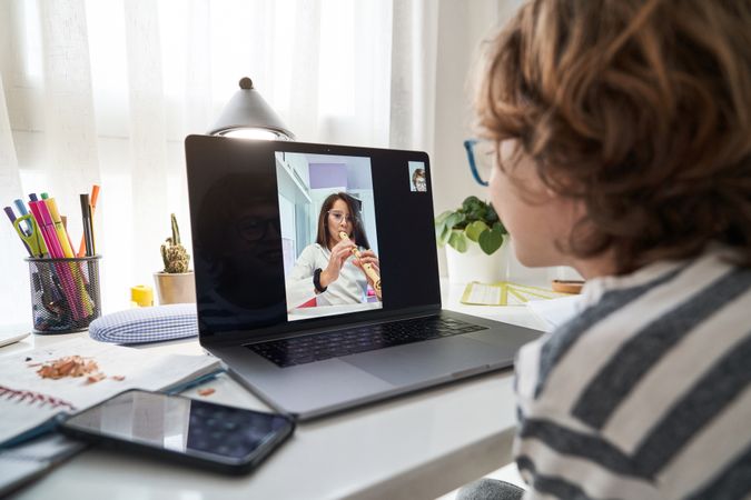 Boy video chatting with girl playing flute