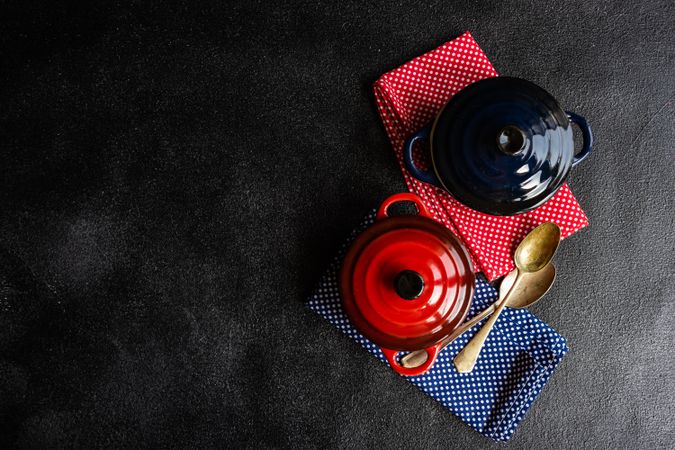 Top view of two red & blue cast iron pan on dotted kitchen towels with copy space