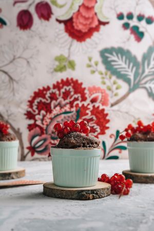 Three Chocolate cakes in the cup with currants and sugar glass.