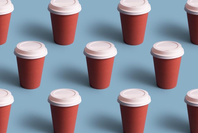 Three rows of disposable coffee cups on blue background