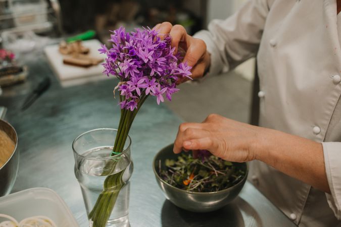 Woman preparing salad by hands at decorated table
