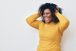 Black woman holding both hands to her head expressing frustration