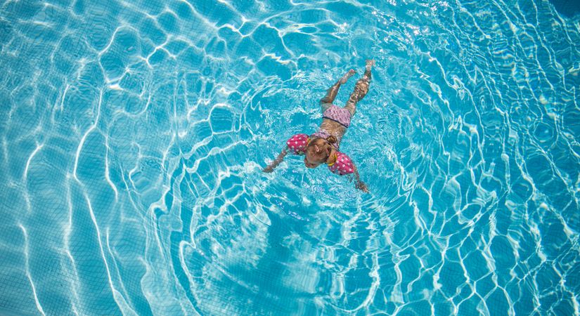 Above view of child swimming in pool