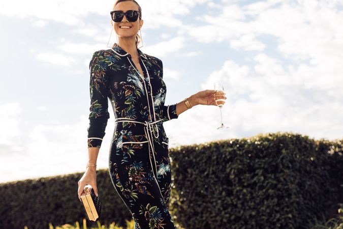 Stylish woman walking with glass of wine