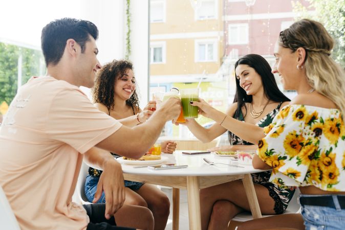 Diverse friends clinking glasses with smoothies
