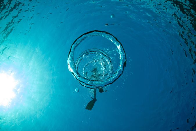 Man snorkeling in water with bubbles