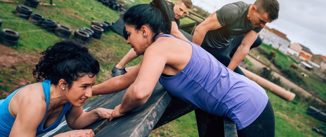 Participants in obstacle course climbing pyramid obstacle
