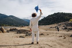 Back of man in jumpsuit with blue flag