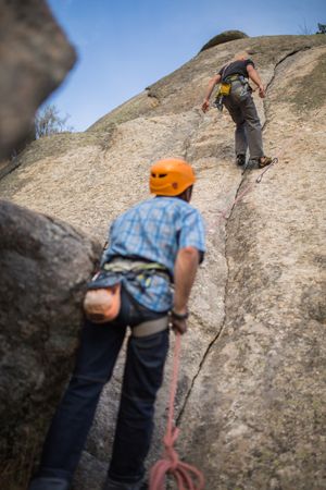 Climbers in safety harness climbing mountain