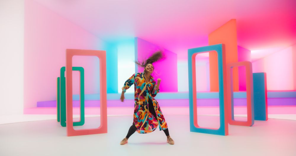Smiling Black Woman Dancing Energetically in a Colorful Abstract Neon Lit Studio. Talented Stylish Female Dancer Performing a Modern Choreography, Having Fun, Making Moves, Practicing.