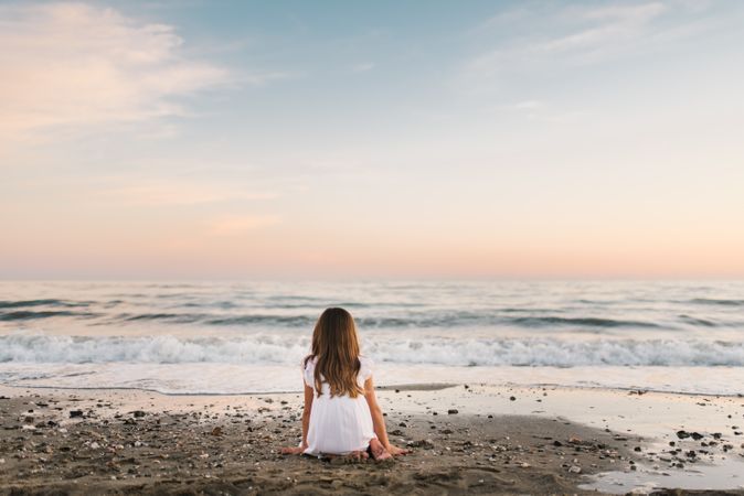 back view girl sitting on beach in daylight