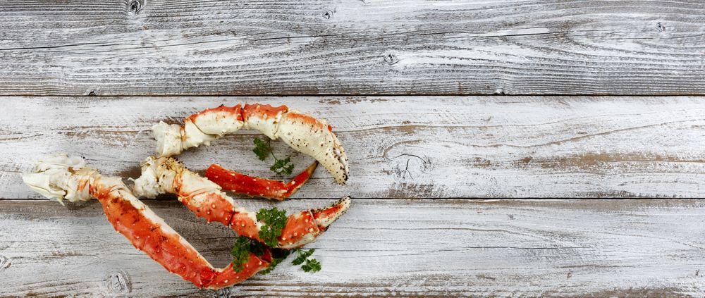 King crab claws on rustic wood in flat lay format