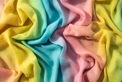 Gradient yellow blue pink and green fabric wavy crumpled background texture.