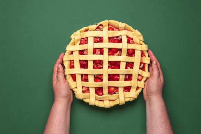Uncooked fruit pie grabbed by hands