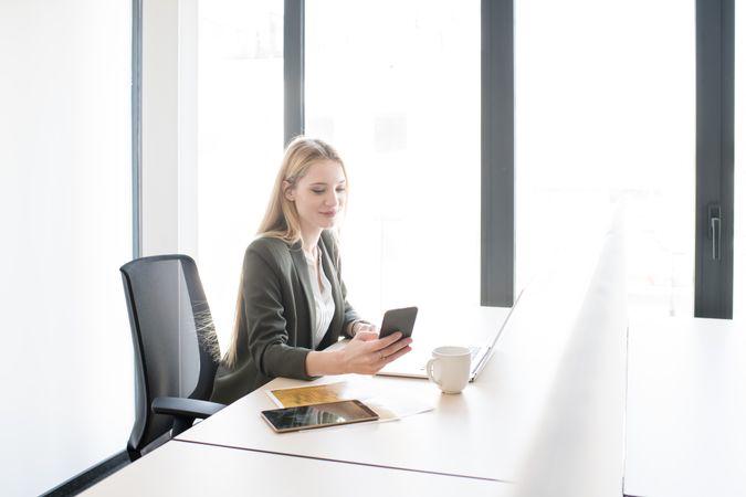 woman in office using smartphone
