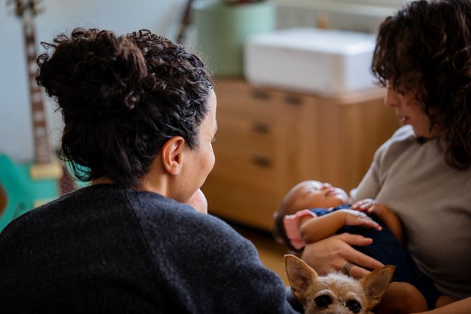 Loving female couple rocking baby to sleep in living room