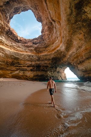Man walking on a shore inside Benagil sea cave