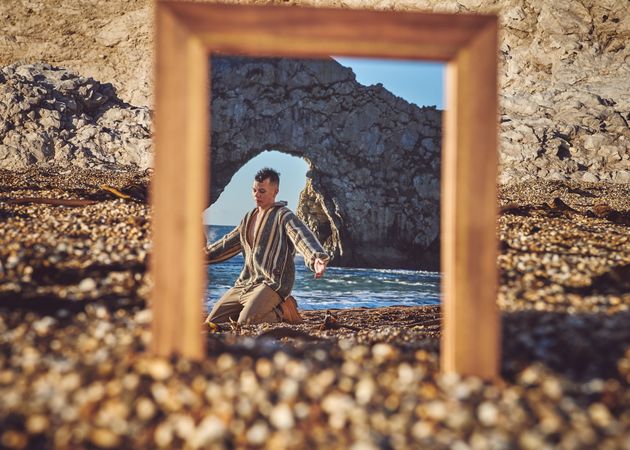 Young man reflected in the mirror at the beach