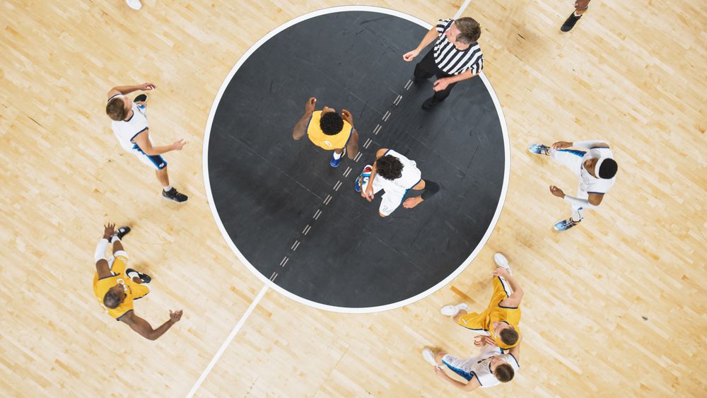Basketball Match Cinematic Top Down View Shot: Two Multiethnic Opposing Team Players Fighting for Possession of the Ball.
