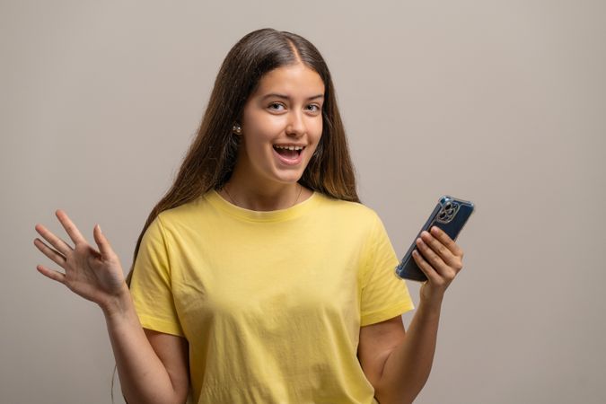 Excited young woman celebrating good news on her smartphone.