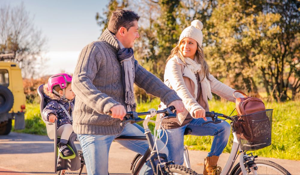 Mother and father taking little girl for bike ride