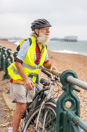 Happy older man with bike looking at coastal view