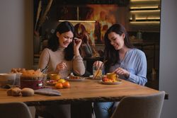 Happy women laughing and cake at home