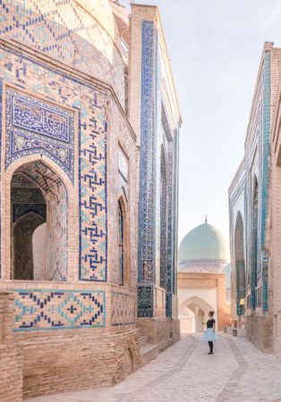 Woman walking near ornamental Islamic building