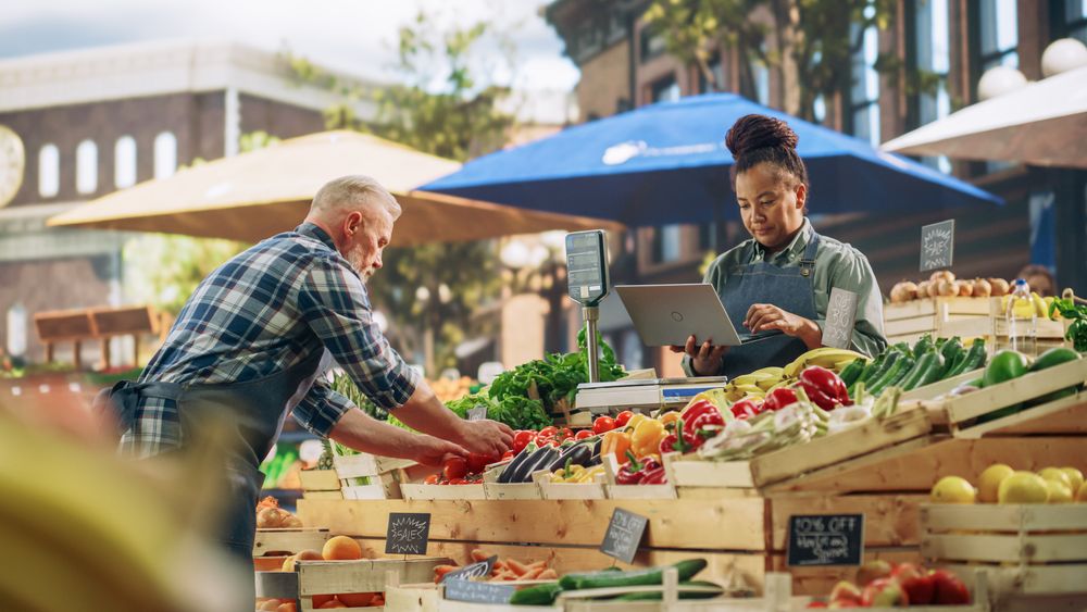 Diverse Couple Selling Ecological Fruits and Vegetables From an Outdoors Food Stand.