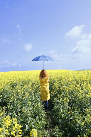 Woman holding umbrella in a field of flowers