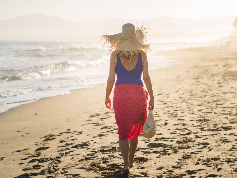 Woman holding walking along seaside
