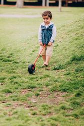 Little boy pushing a wheel at a park