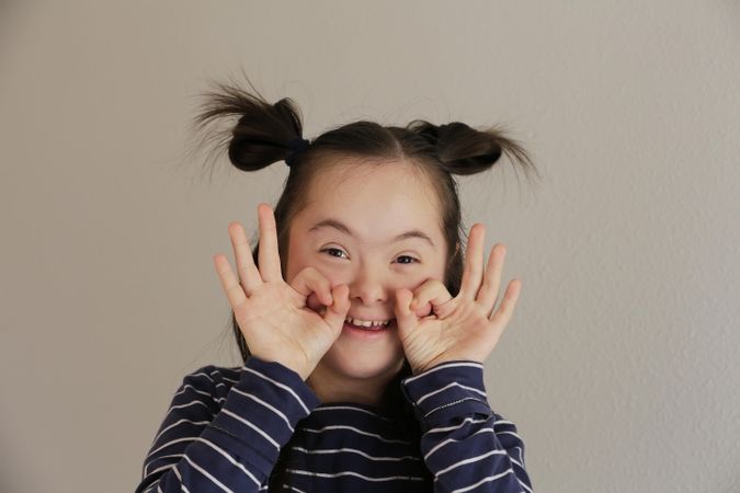 Playful child with Down syndrome smiling at the camera