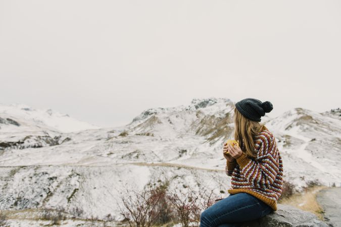 Young woman with cup between mountains