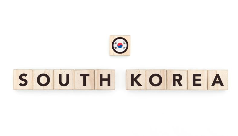 Wooden blocks bearing the name and flag of South Korea. South Korean and Asian Culture, national identity, travel, and geography in a copy space design.