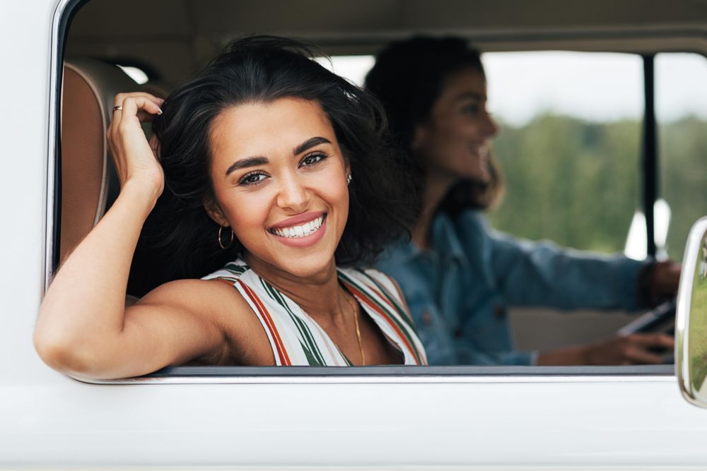 Beautiful woman smiling at the camera from the passenger seat of a van