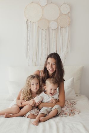 Content young mother with little kids at bedroom