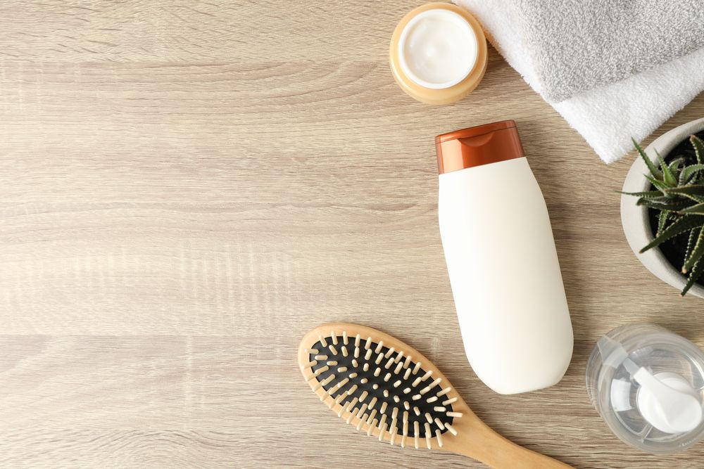 Composition with hair care products on wooden background, top view