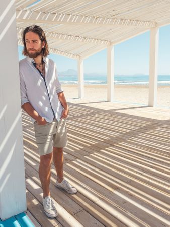 Relaxed man standing in gazebo on beach